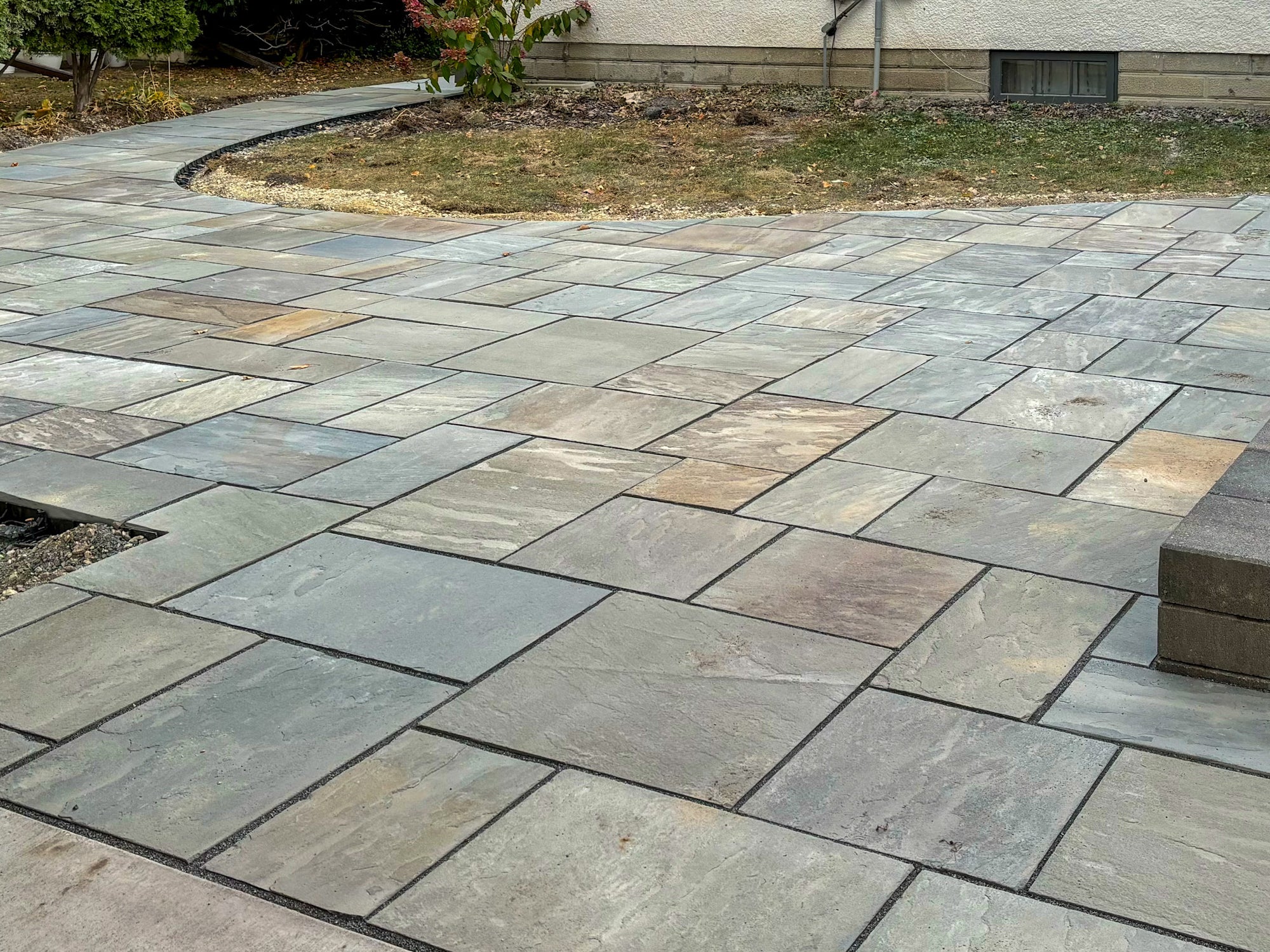 Bluestone patio installation in progress in Minneapolis showing natural stone placement and ashlar pattern alignment during construction.