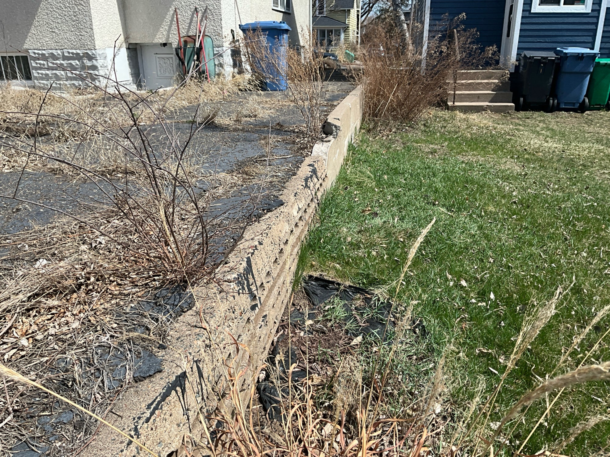 Before: Cracked asphalt driveway and failing retaining wall in Bryn Mawr Minneapolis