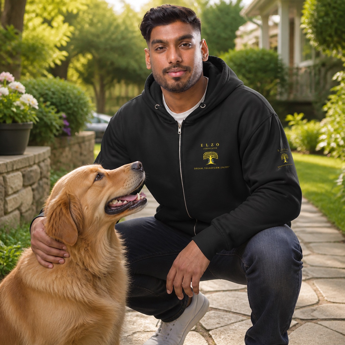 ELZO team member wearing the Dog’s Favorite Landscaper hoodie with a dog in a garden