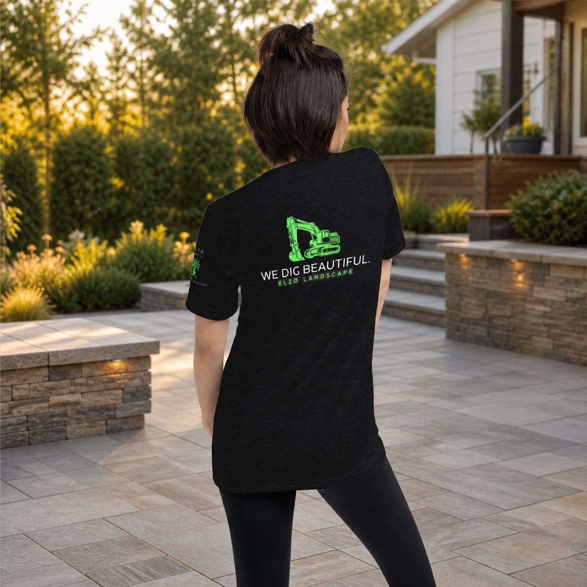 ELZO team member wearing the We Dig Beautiful tee beside a finished patio